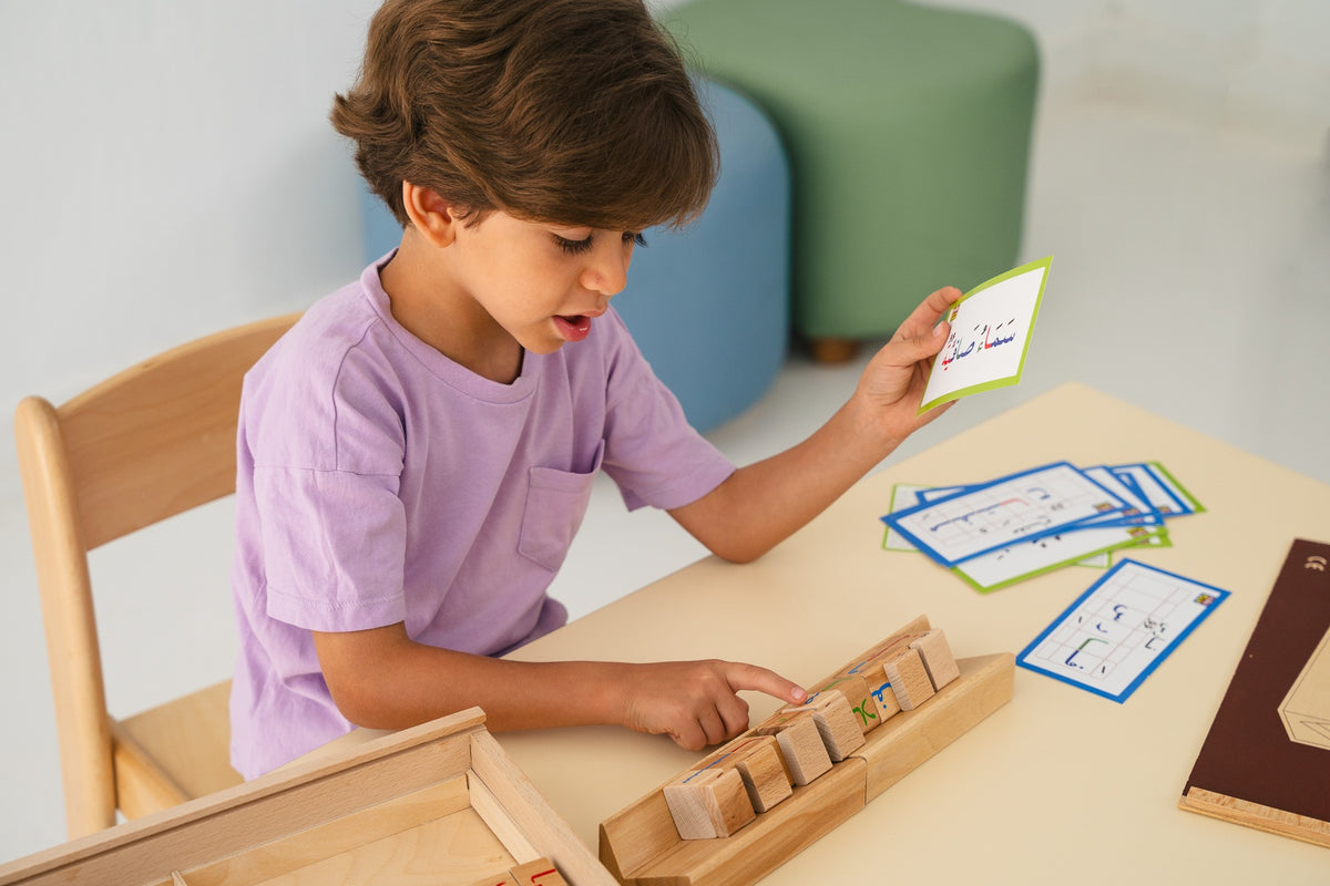 A child matching an Arabic word card with wooden Arabic letter blocks.